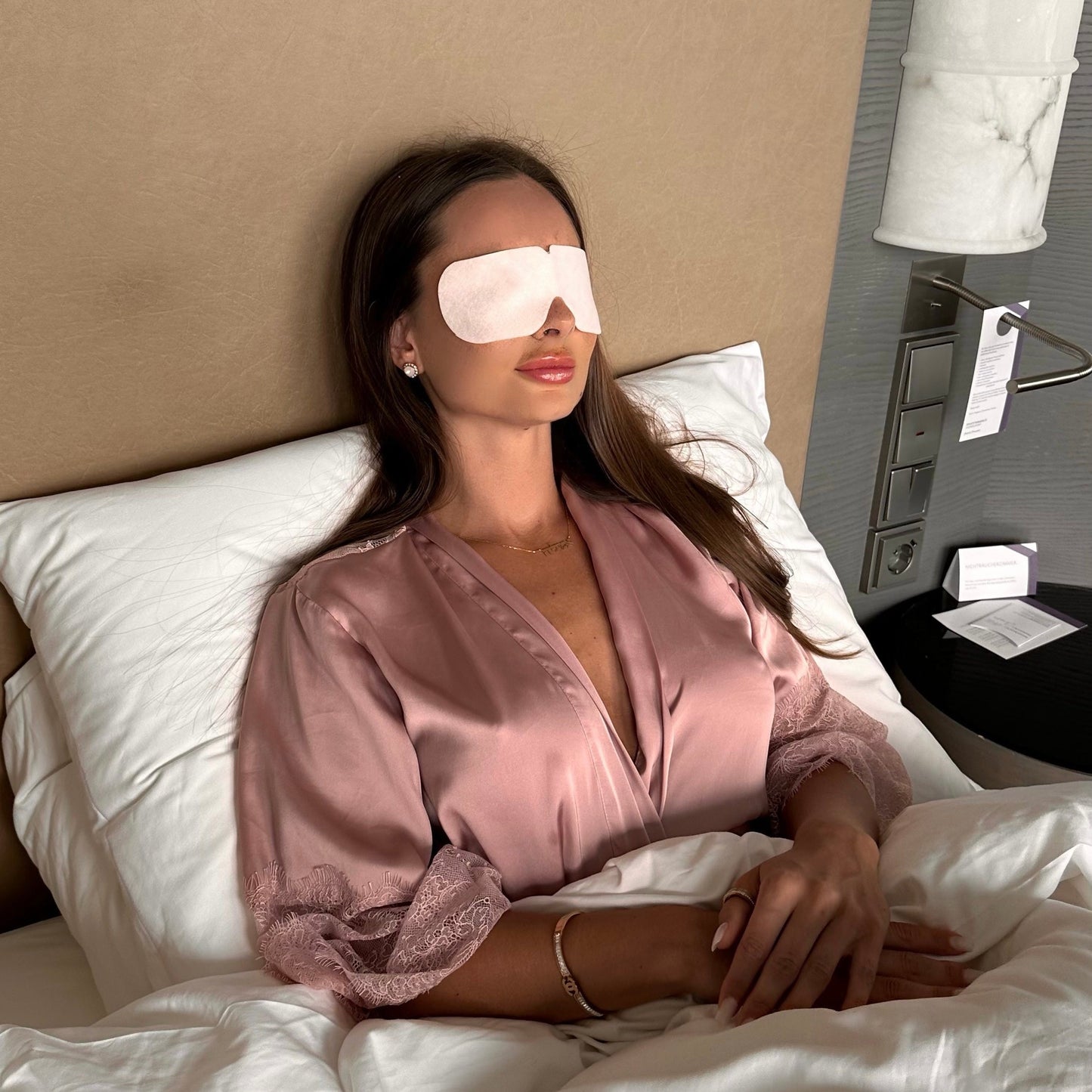 Realxees ist kühlende Augenmaske zum entspannen und gegen Augenschmerzen. Relaxees helfen Augenringe zu reduzieren. Eine Frau liegt entspannt mit Relaxees auf den Augen im Bett.