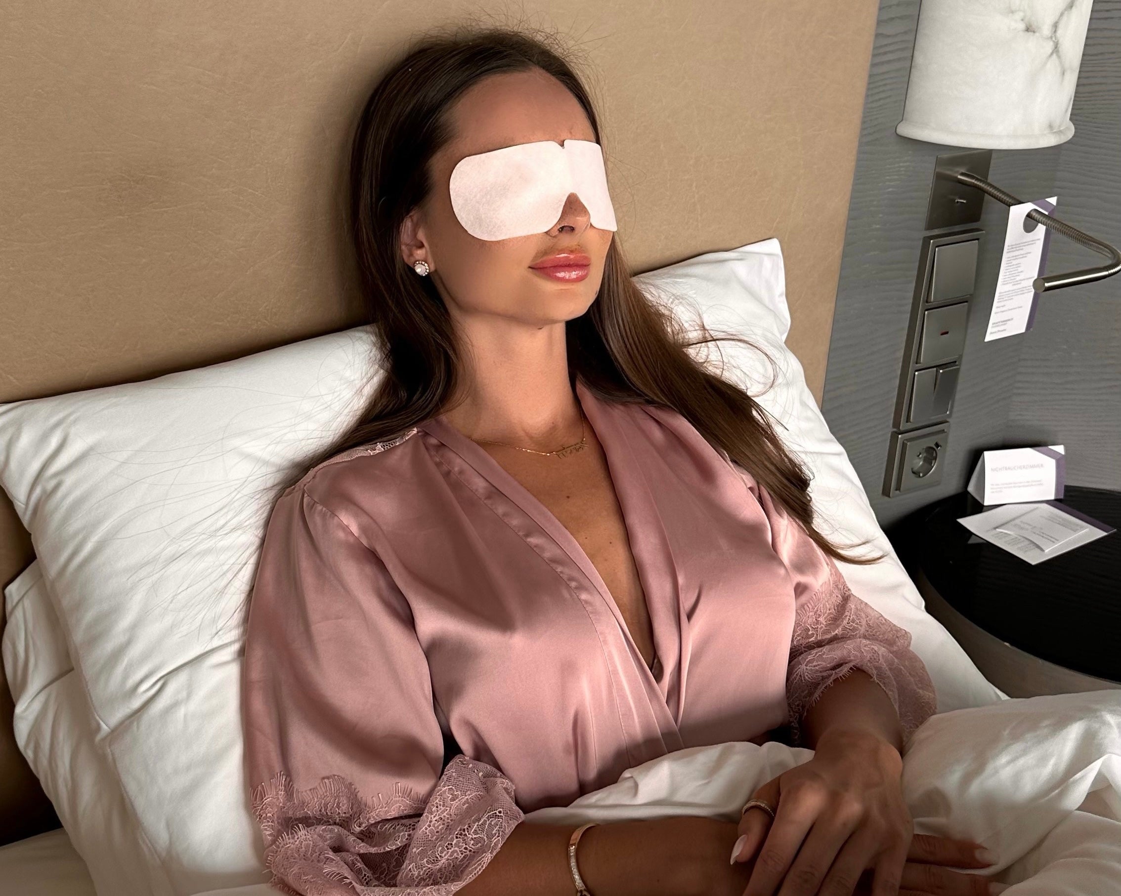 Relaxees ist kühlende Augenmaske zum entspannen und gegen Augenschmerzen. Relaxees helfen Augenringe zu reduzieren. Eine Frau liegt entspannt mit Relaxees auf den Augen im Bett